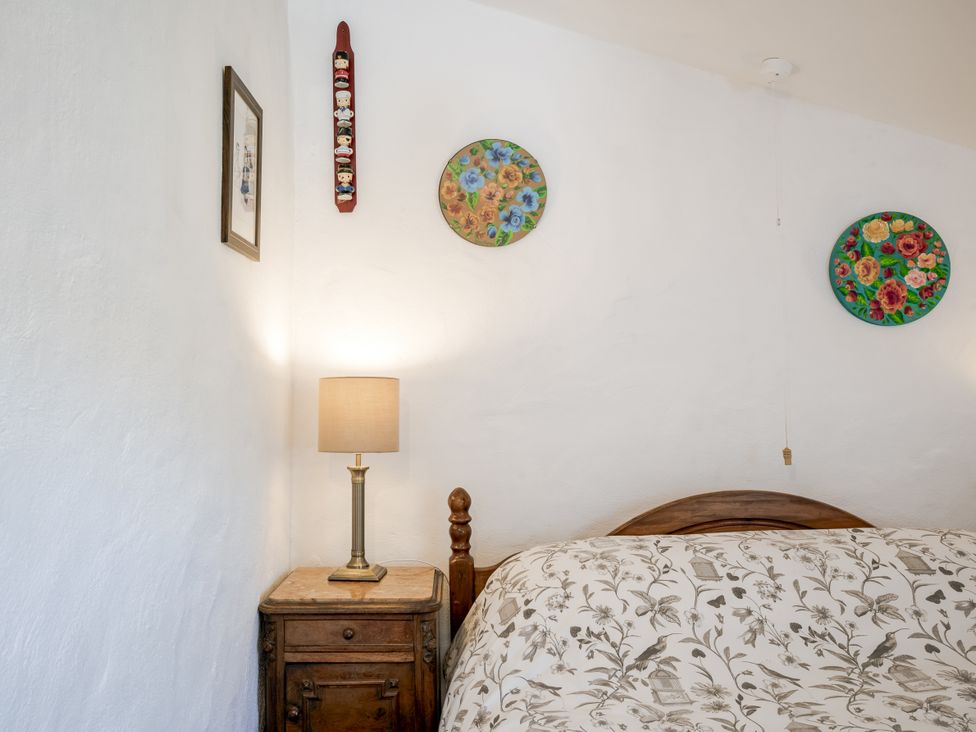 A bedroom with a bed and lamp at Coach House in Llangrannog