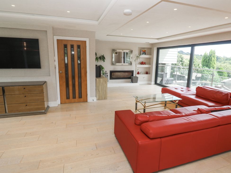 A living room with a television and red couch at Treliance in Truro