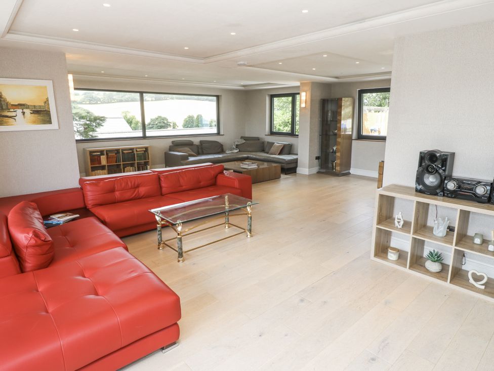 A living room with a red sofa and coffee table at Treliance in Truro