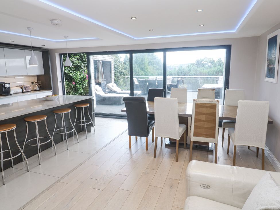 A dining area with a kitchen island and dining table at Treliance in Truro