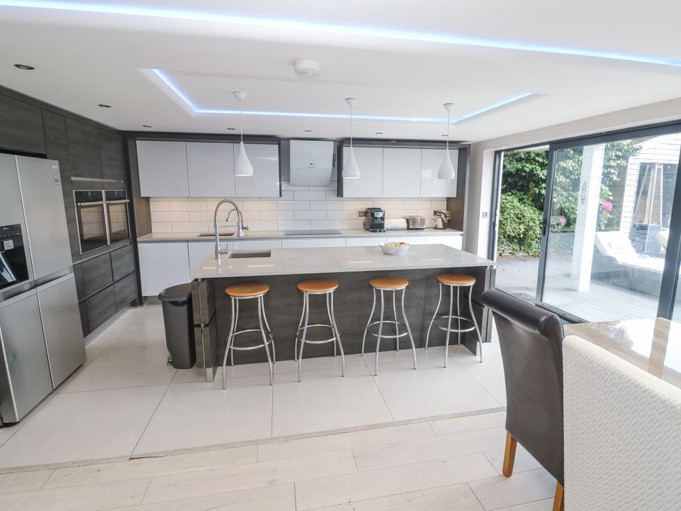 A kitchen with an island and bar stools at Treliance in Truro