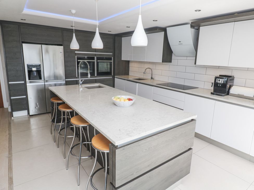 A kitchen with an island and stools at Treliance in Truro