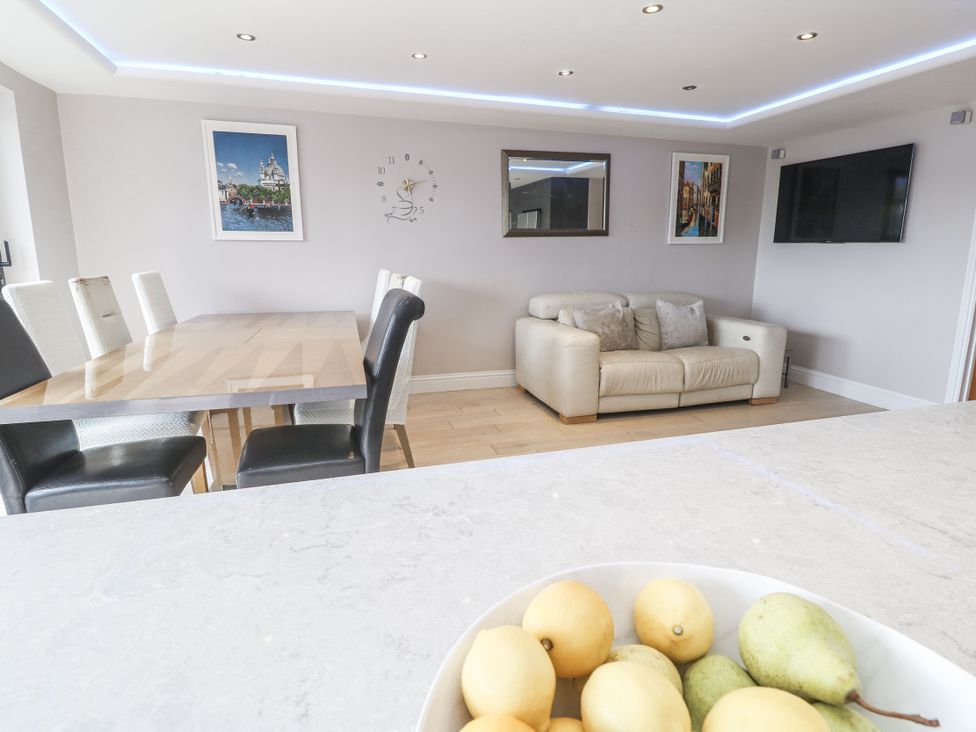 A dining room with a table and chairs and a sofa at Treliance in Truro