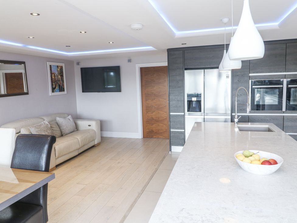 A kitchen with a couch and dining table at Treliance in Truro