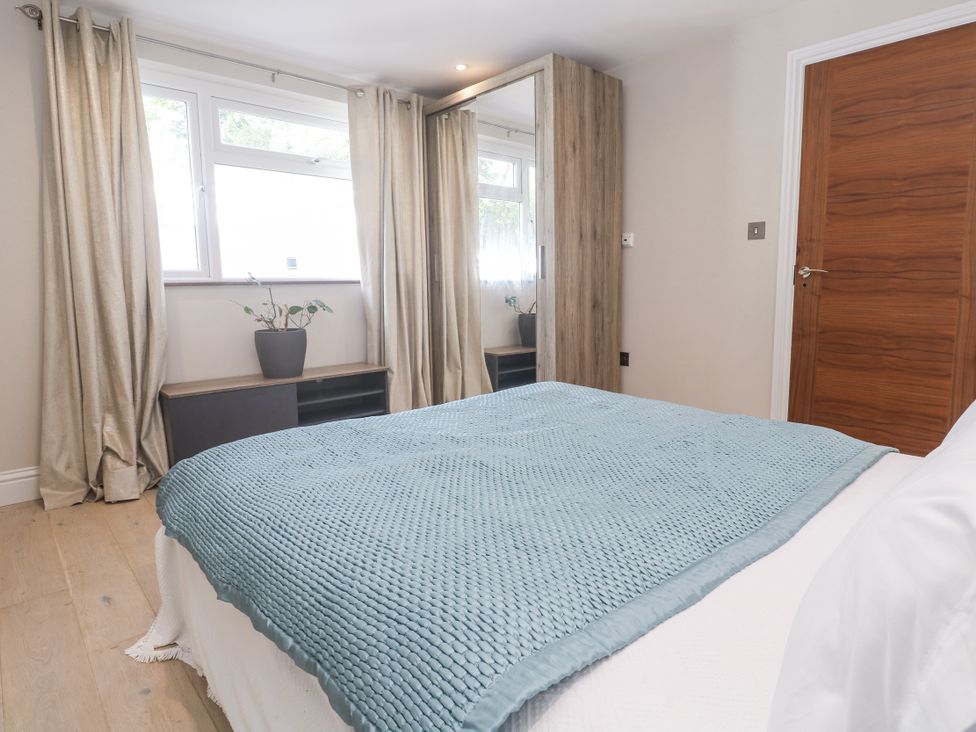 A bedroom with a bed and curtains at Treliance in Truro