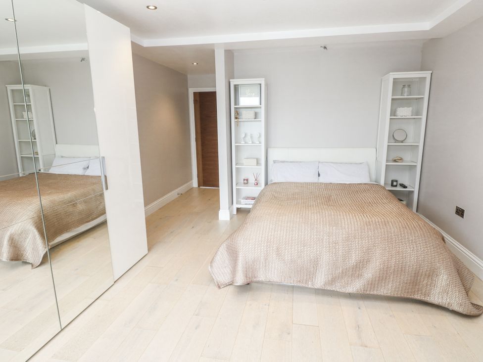 A bedroom with a bed and shelves at Treliance in Truro