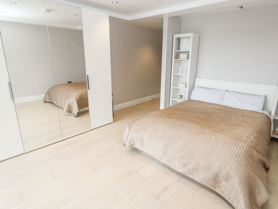 A bedroom with a bed and mirror at Treliance in Truro