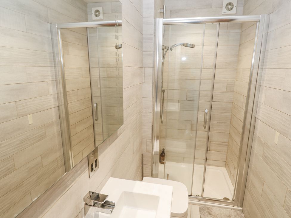 A bathroom featuring a shower, sink and mirrors at Treliance in Truro