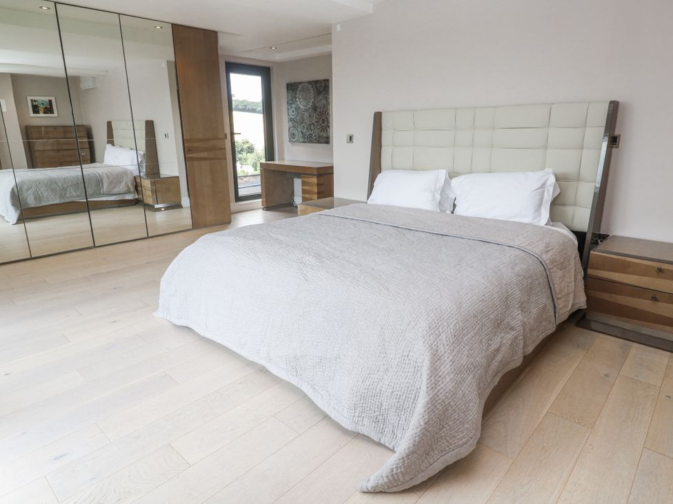 A bedroom with a bed and mirrored wardrobe at Treliance in Truro