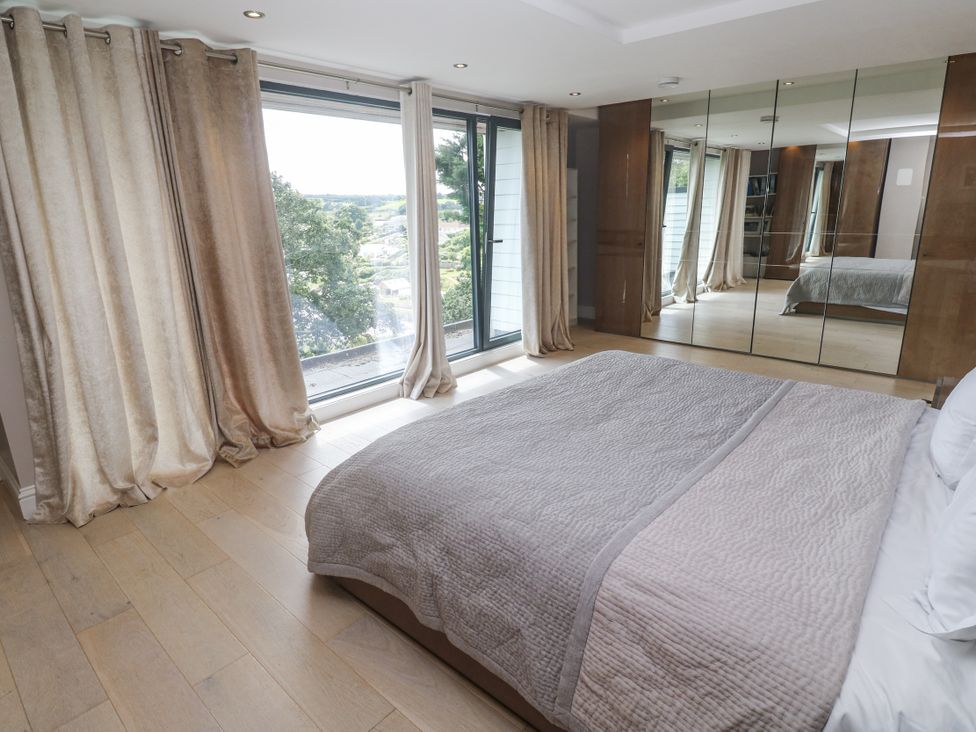 A bedroom with a bed and sliding doors at Treliance in Truro