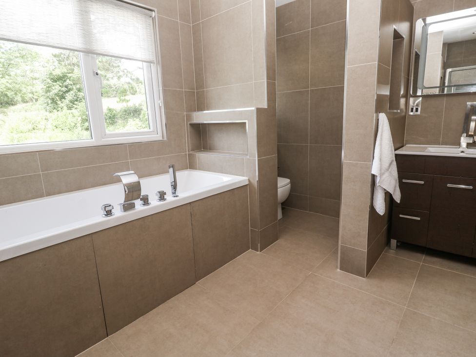 A bathroom with a bathtub, toilet, and sink at Treliance in Truro