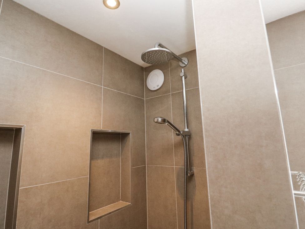 A shower with a showerhead and wall niches at Treliance in Truro