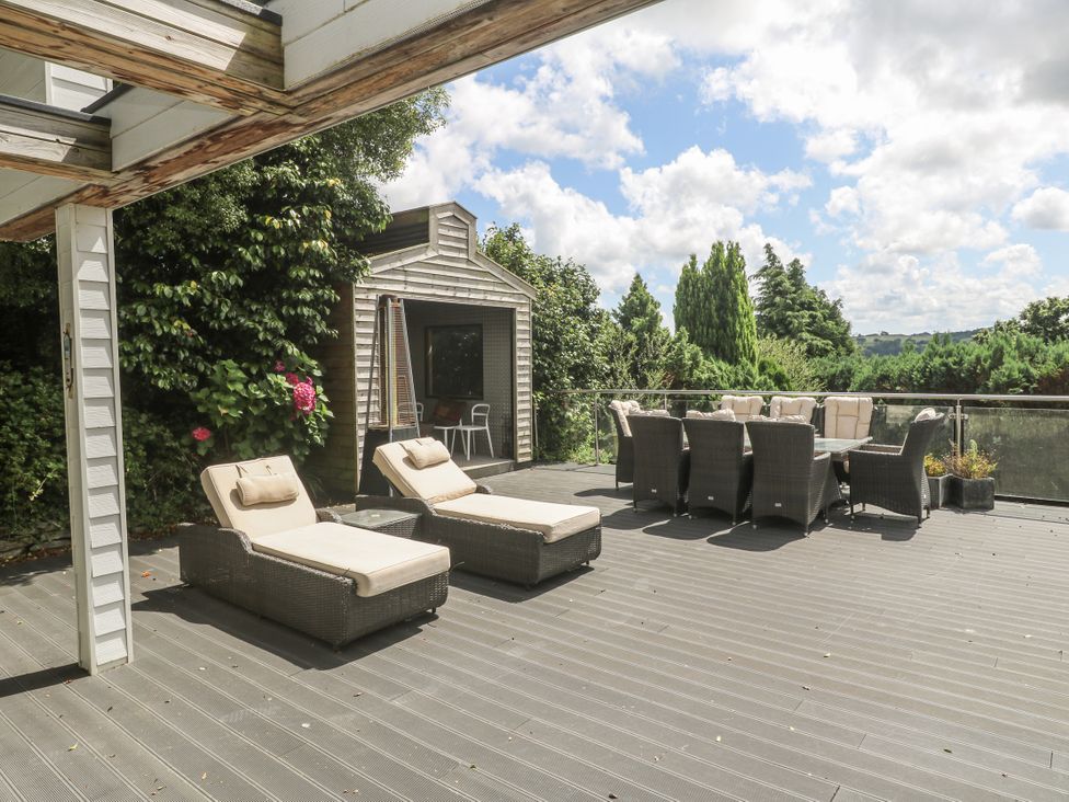 An outdoor patio with loungers and a dining area at Treliance in Truro