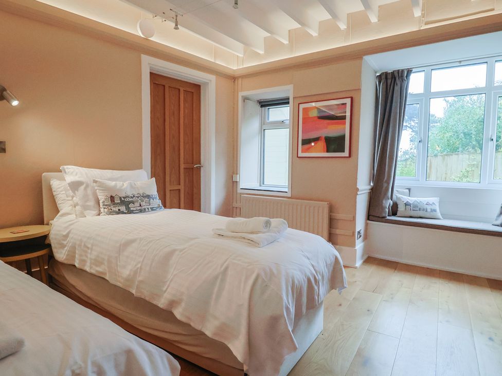 A bedroom with two beds and a window at The Well House in Lyme Regis