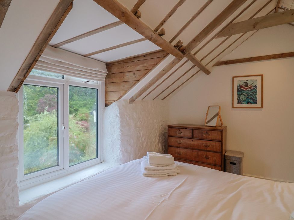 A bedroom with a bed and window at The Well House in Lyme Regis
