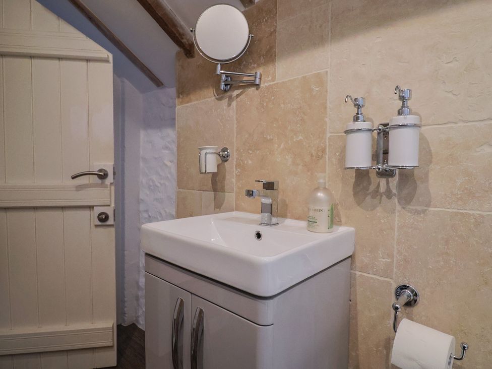A bathroom with a sink and mirror at The Well House in Lyme Regis