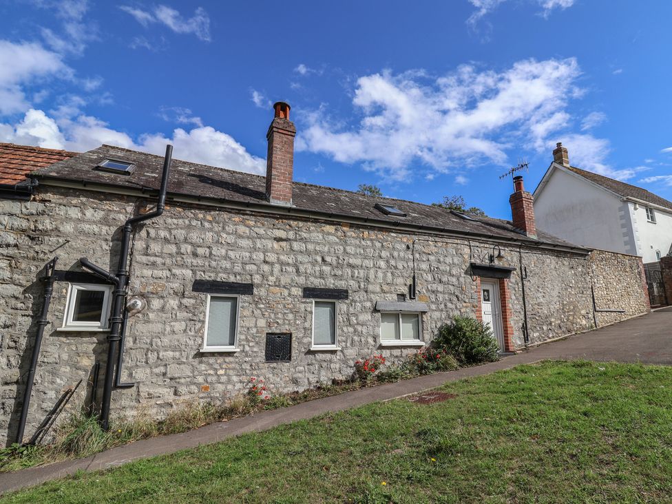 An outdoor view of a stone property with windows and a door at The Well House in Lyme Regis