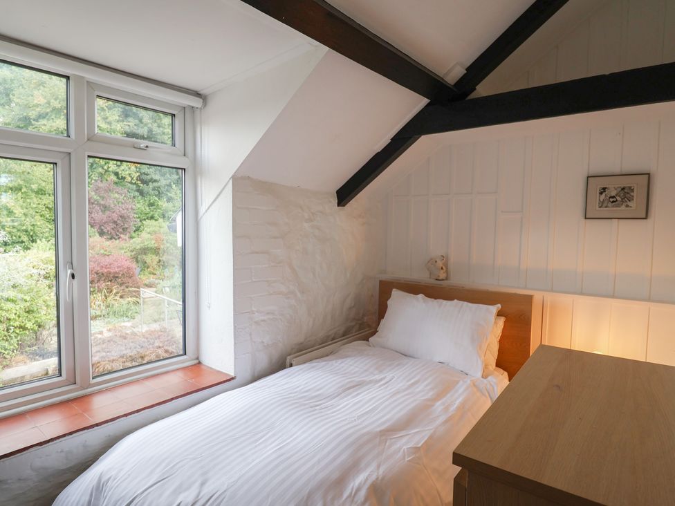 A bedroom with a bed and window at The Well House in Lyme Regis