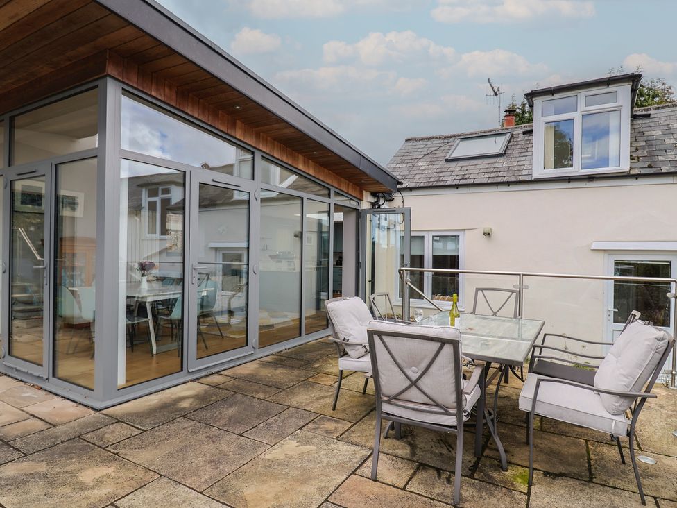 An outdoor seating area with a table and chairs at The Well House in Lyme Regis