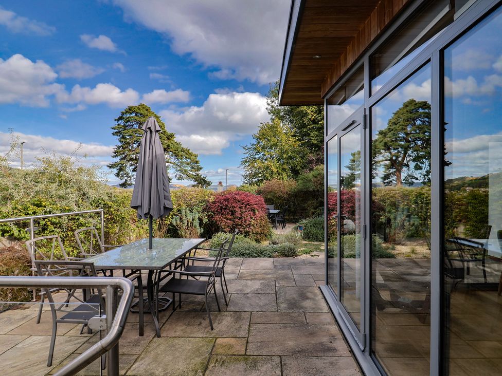 An outdoor patio with a table and chairs at The Well House in Lyme Regis
