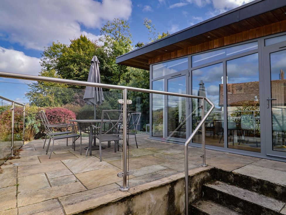 An outdoor area with seating and an umbrella at The Well House Lyme Regis