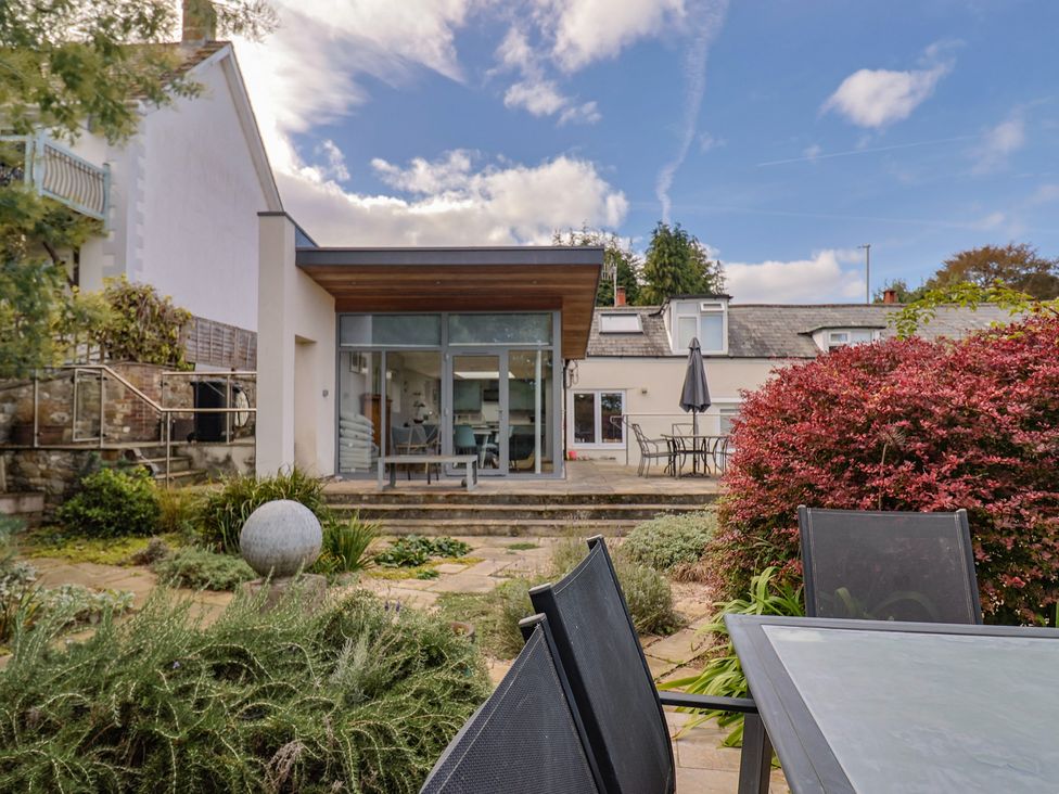A garden with a patio area and table at The Well House in Lyme Regis