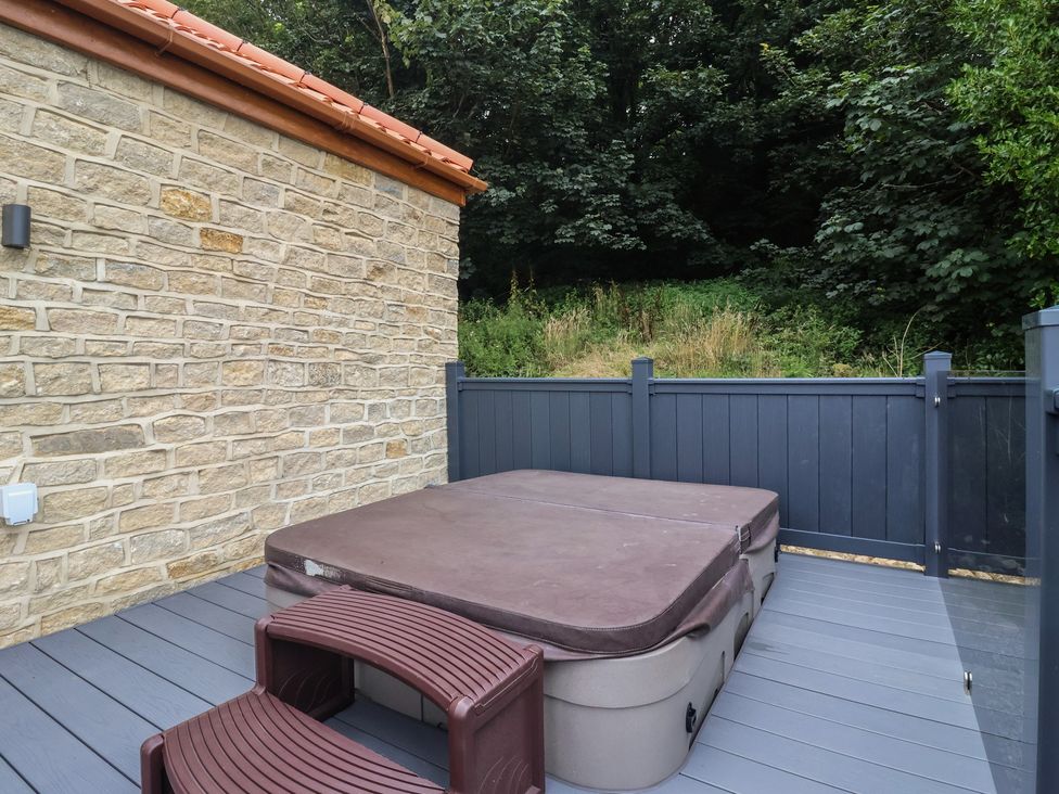 An outdoor area with a hot tub and wooden deck at Castle View in Scarborough