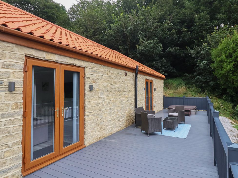 An outdoor patio with furniture and a stone wall at Castle View in Scarborough