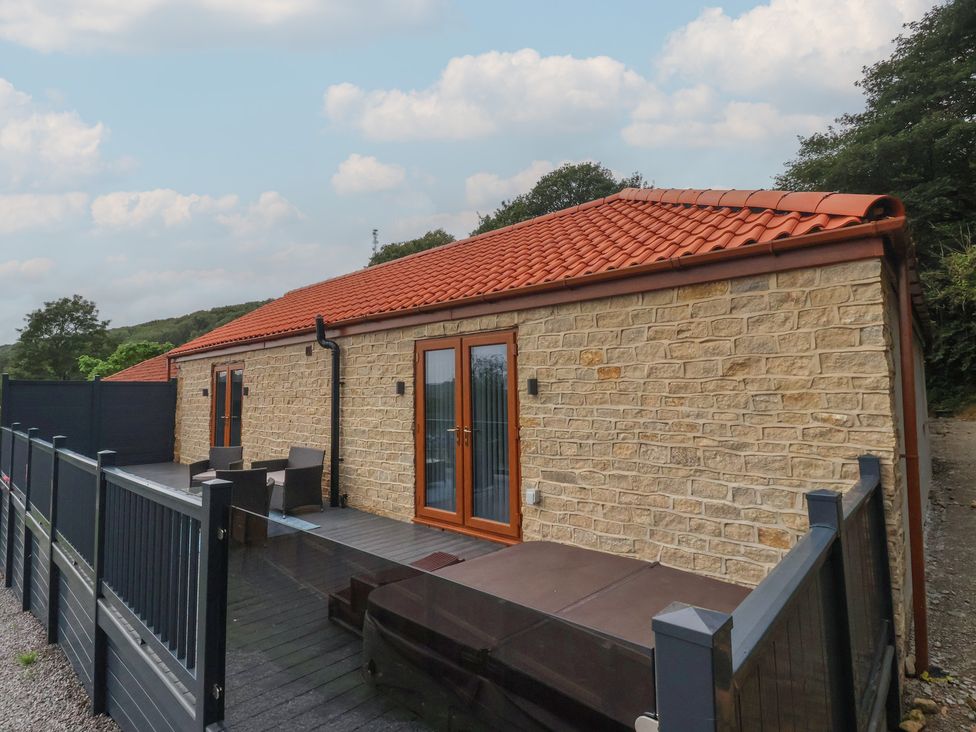 A stone building with a deck and hot tub at Castle View in Scarborough