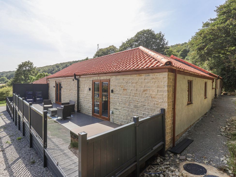 An outdoor area with a deck and chairs at Castle View in Scarborough
