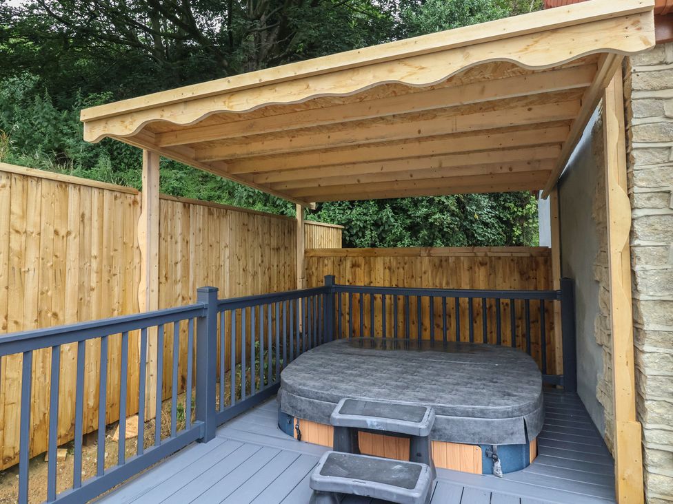 An outdoor area with a hot tub under a roof at Woodside in Scarborough