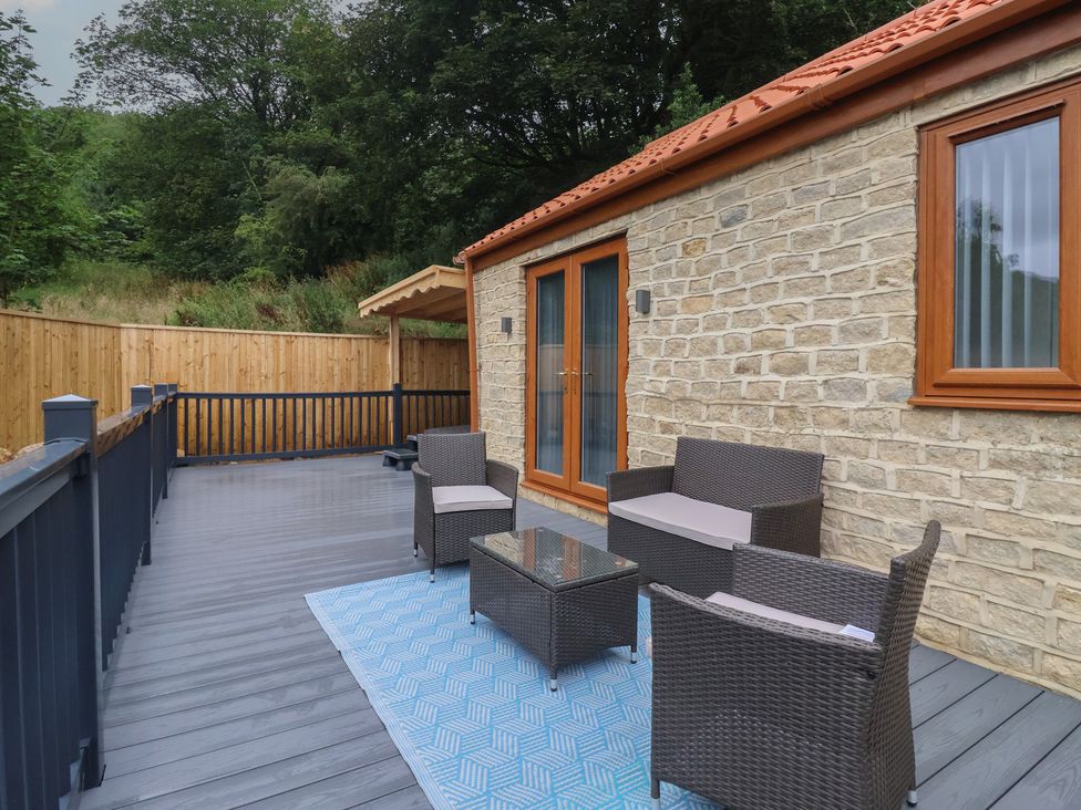 An outdoor seating area with furniture and a stone house at Woodside in Scarborough