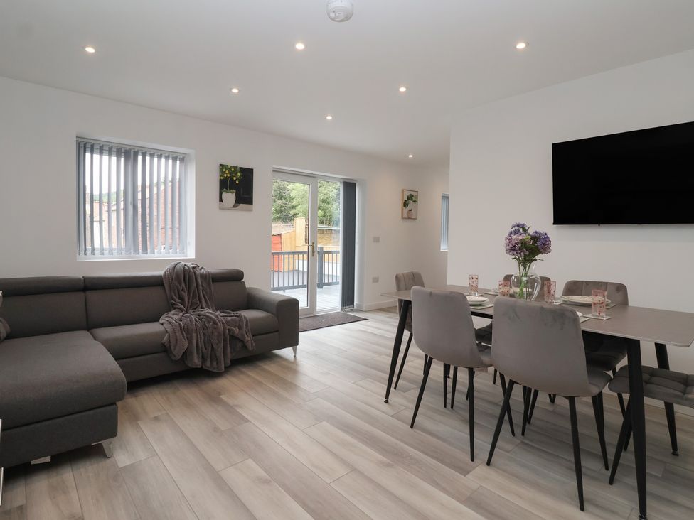 A living room with a sofa and dining area at Woodside in Scarborough