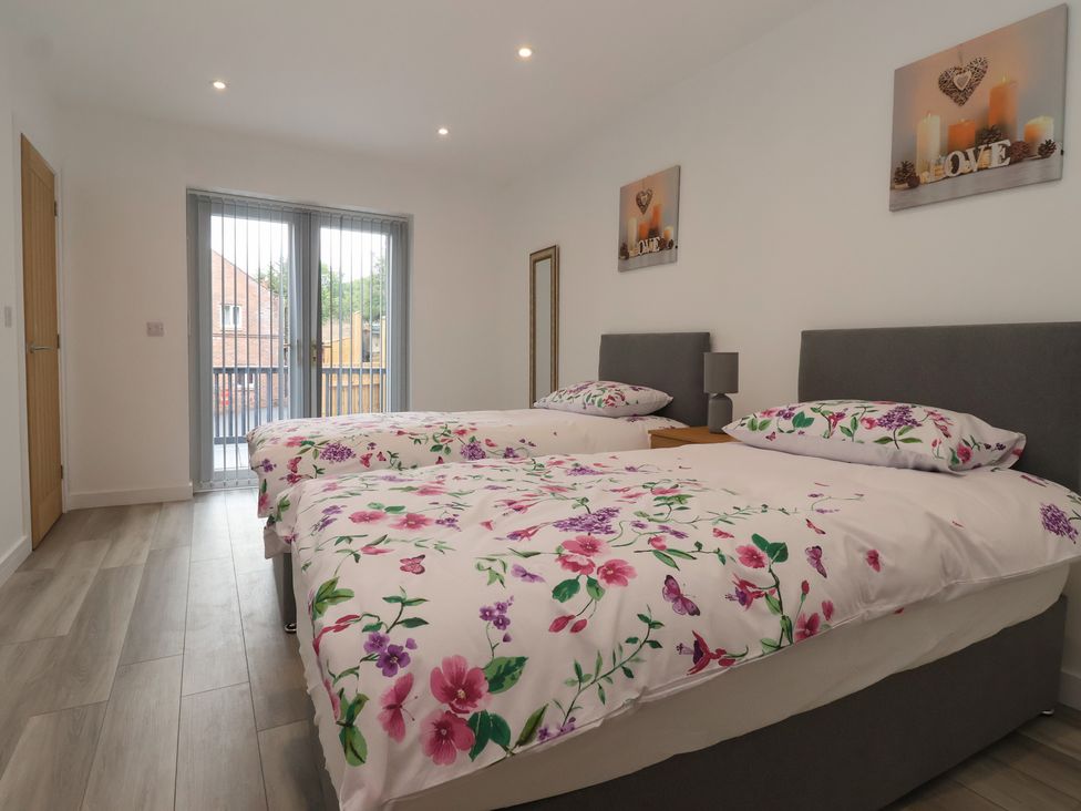 A bedroom with two beds and sliding doors at Woodside in Scarborough
