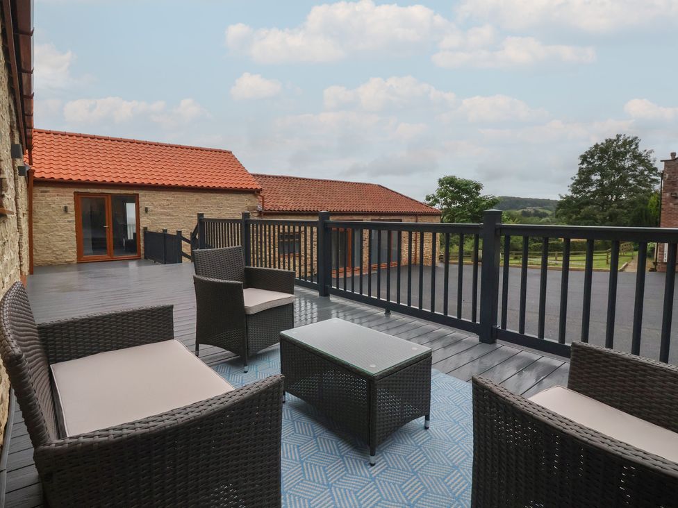 An outdoor terrace with seating area and table at Woodside in Scarborough