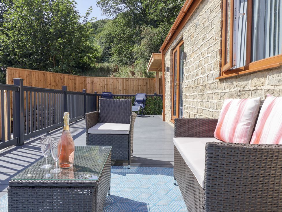 An outdoor seating area with a coffee table and sofa at Woodside in Scarborough