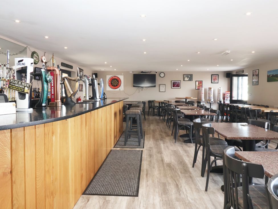 A bar with seating and a dartboard at Woodside in Scarborough