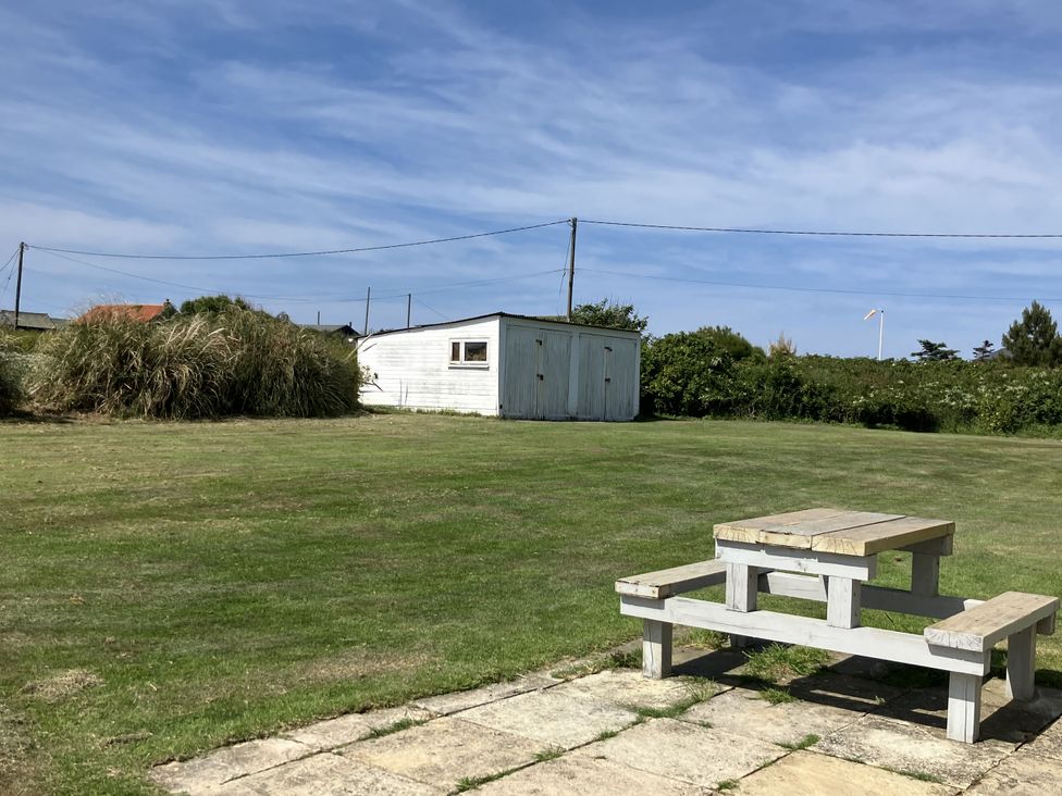 An outdoor area with a table and a shed at Seadrift near Stalham