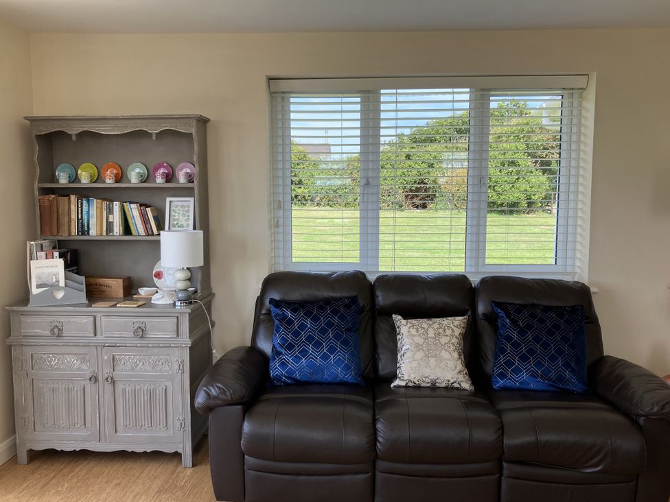 A living room with a sofa and shelf at Seadrift near Stalham