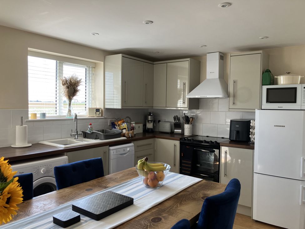 A kitchen with appliances and dining area at Seadrift near Stalham