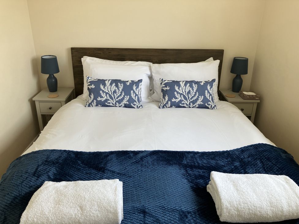 A bedroom with a bed and bedside table at Seadrift near Stalham