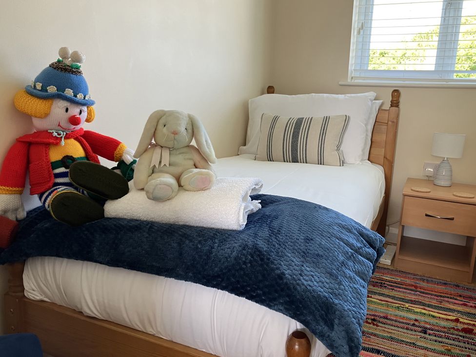 A bedroom with a bed, toys, and a nightstand at Seadrift near Stalham