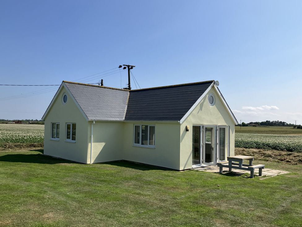 A house with a table and chairs in the yard at Seadrift near Stalham