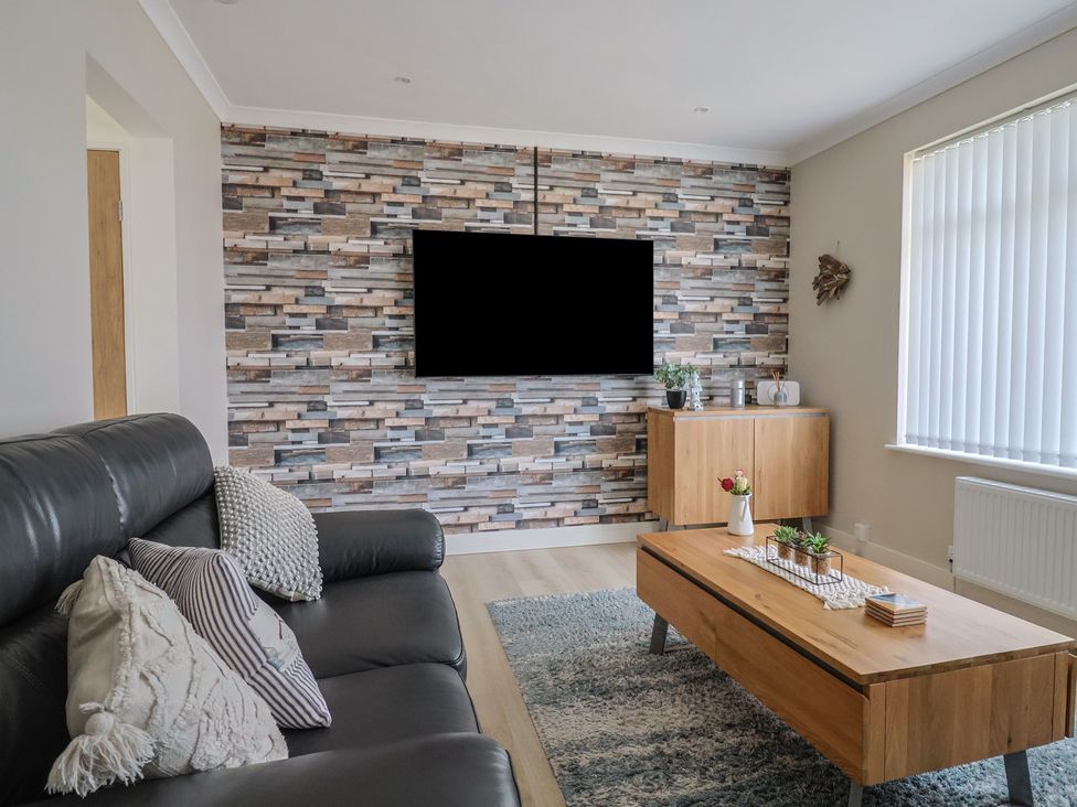 A living room with a tv and coffee table at 7 Cedar Drive Preston