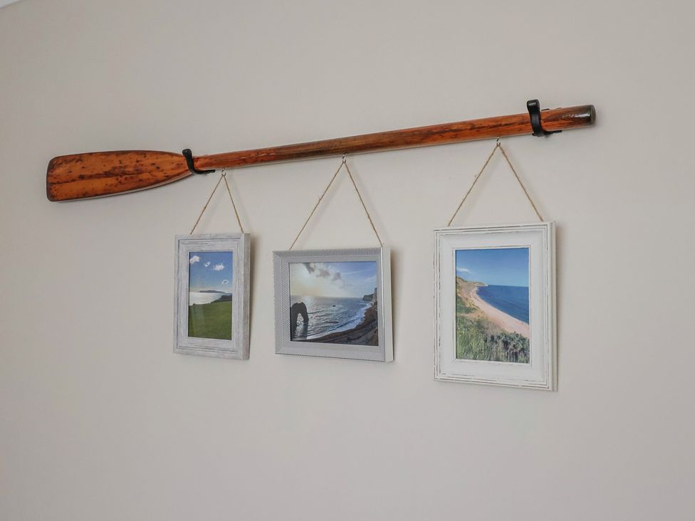 A rowing oar with three picture frames on a wall at 7 Cedar Drive Preston