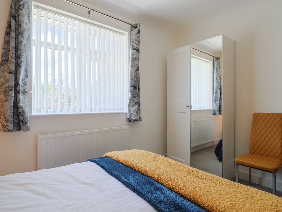 A bedroom with a bed and mirror at 7 Cedar Drive Preston