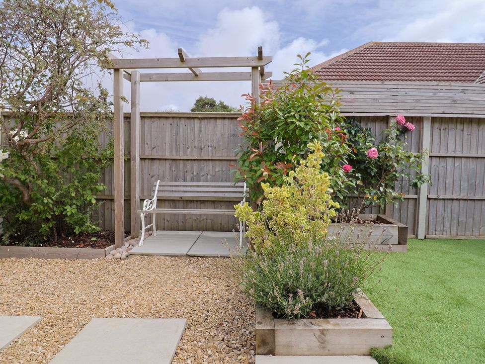 A garden with plants and a bench at 7 Cedar Drive Preston