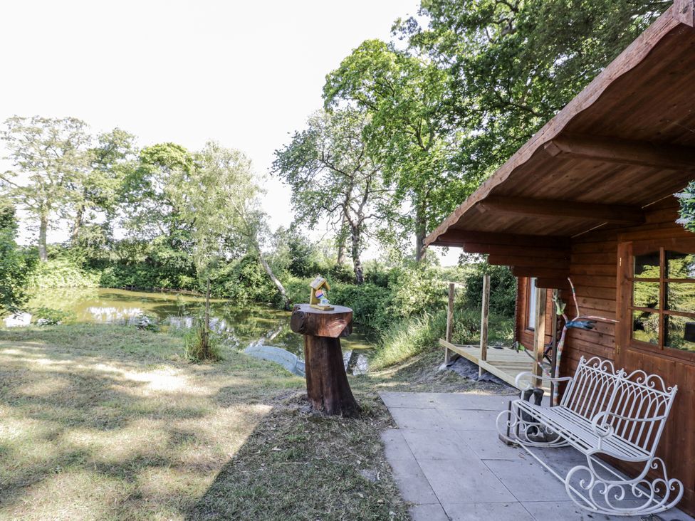 A garden area with a wooden bench and water feature at The Lodge 