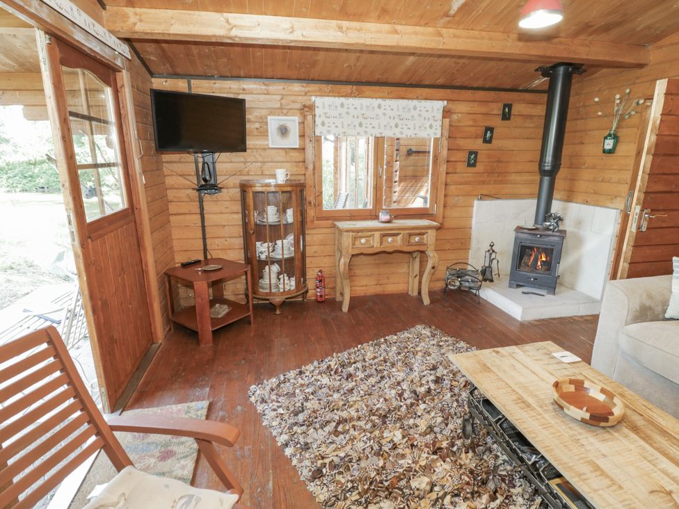 A living room with a sofa and wood stove at The Lodge in 