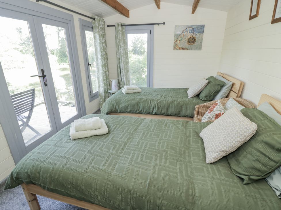 A bedroom with two beds and windows at The Lodge 